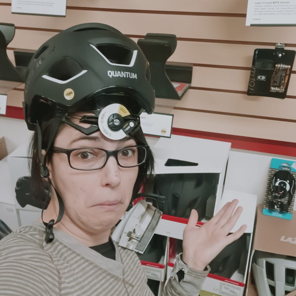 Woman making silly face and wearing a bicycle helmet backwards.